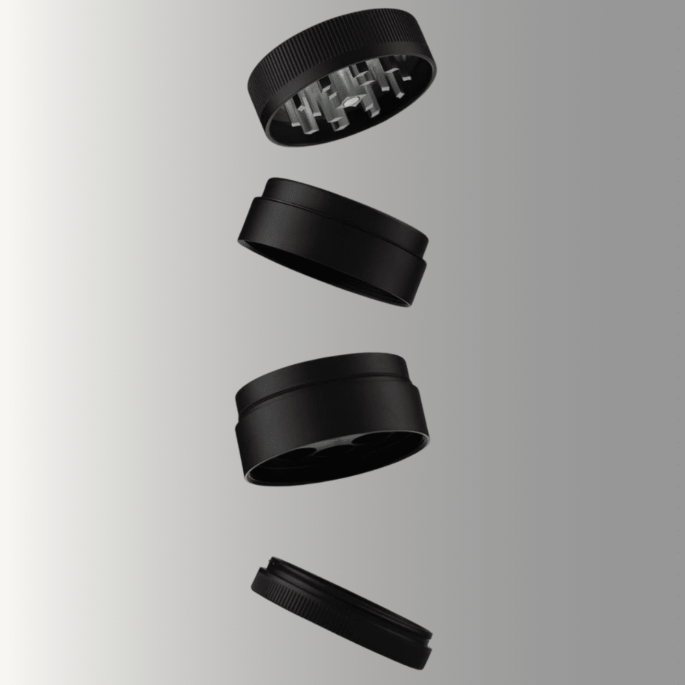 A matte black four-piece herb grinder shown as an exploded view with all sections separated and floating vertically against a grey gradient background. From top to bottom: the lid with grinding teeth visible inside, the upper grinding chamber, the lower collection chamber with a mesh screen, and the flat catch tray at the bottom.